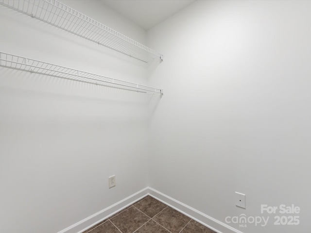 spacious closet featuring dark tile patterned flooring