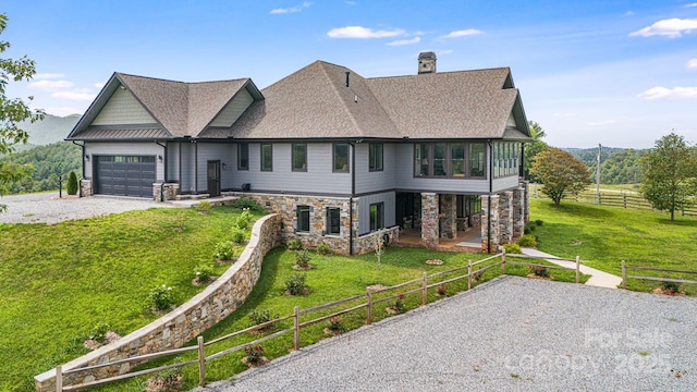 view of front of home featuring a garage, a sunroom, and a front lawn