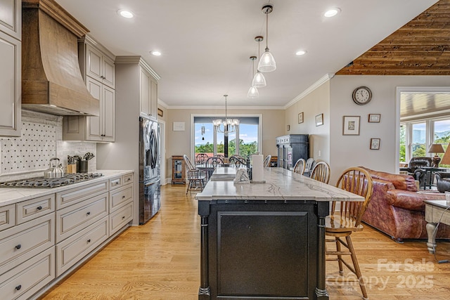 kitchen featuring pendant lighting, a breakfast bar area, stainless steel appliances, a center island, and custom exhaust hood