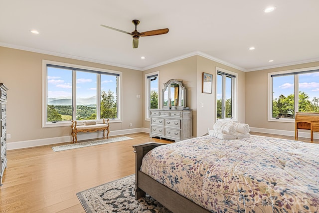 bedroom featuring multiple windows, ornamental molding, and light hardwood / wood-style flooring