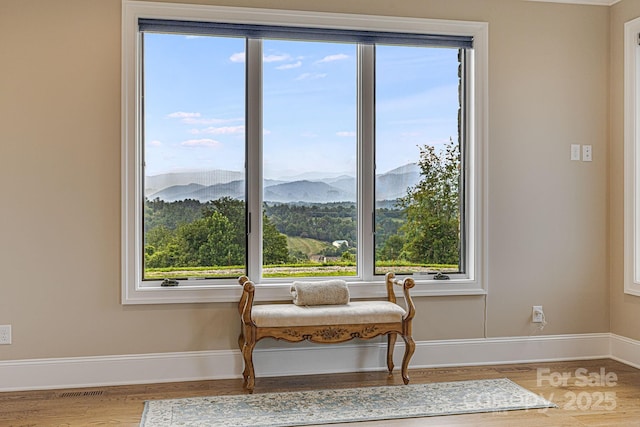 sitting room with wood-type flooring and a mountain view