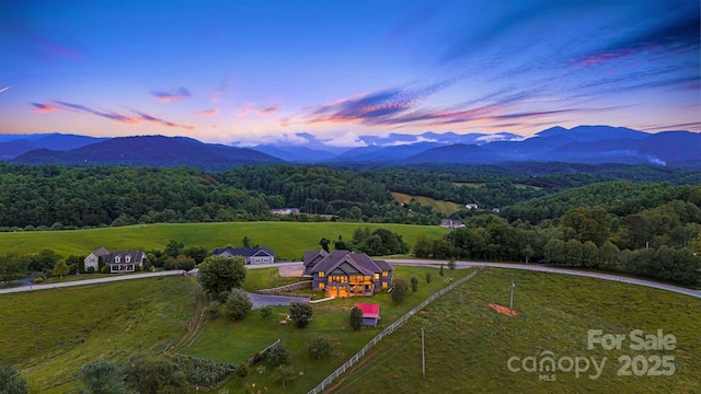 aerial view at dusk featuring a mountain view