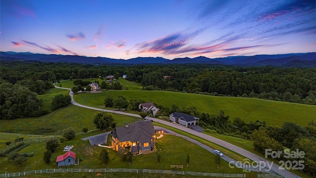 aerial view at dusk with a mountain view and a rural view