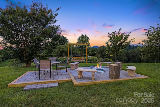 yard at dusk featuring a patio and an outdoor fire pit