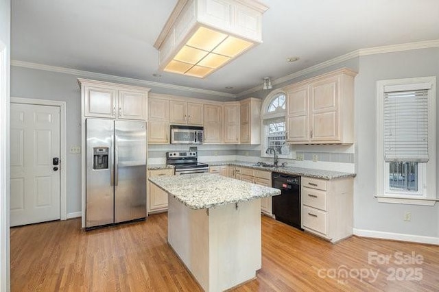 kitchen featuring sink, light stone counters, light hardwood / wood-style flooring, a kitchen island, and stainless steel appliances