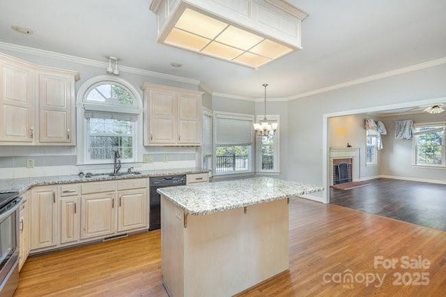 kitchen with sink, light hardwood / wood-style flooring, dishwasher, light stone countertops, and decorative light fixtures