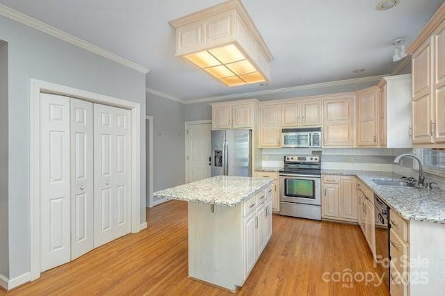 kitchen with stainless steel appliances, a center island, light stone countertops, and light hardwood / wood-style flooring