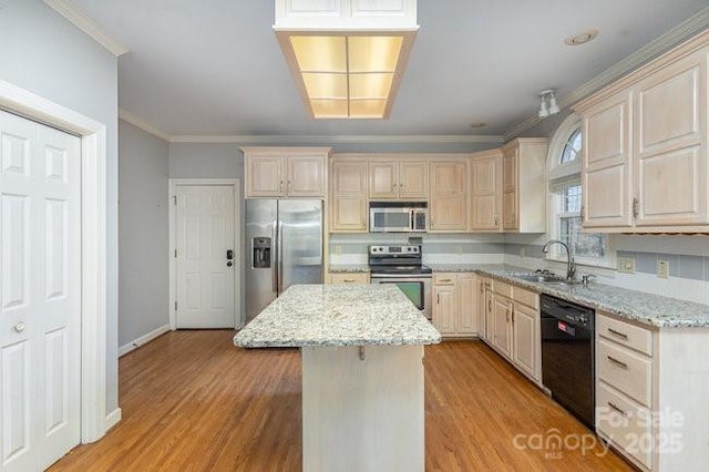 kitchen with sink, a kitchen island, light stone countertops, and appliances with stainless steel finishes