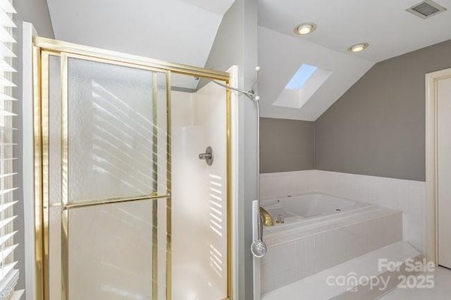 bathroom with vaulted ceiling with skylight and separate shower and tub