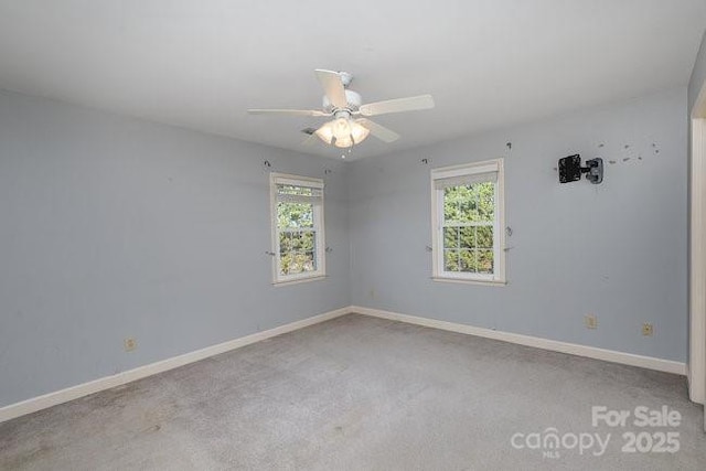 carpeted spare room featuring ceiling fan