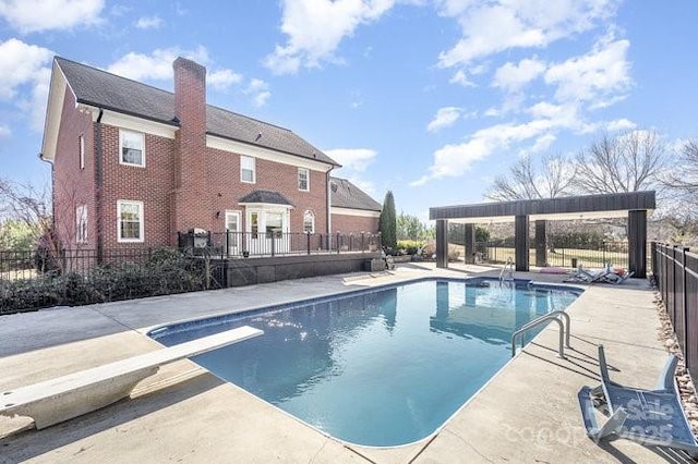 view of pool featuring a pergola, a patio, and a diving board