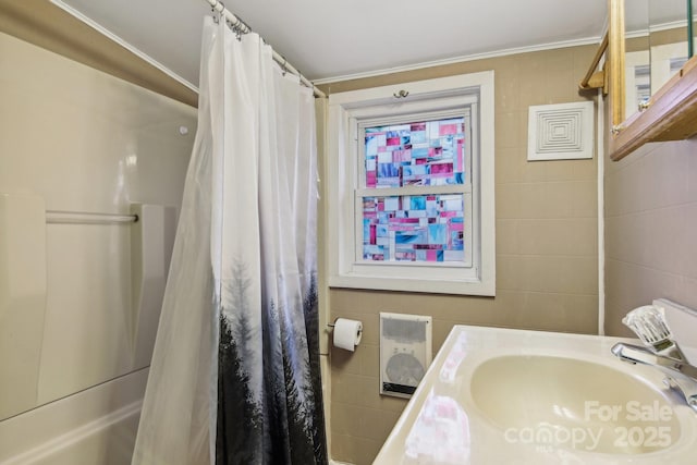 bathroom with tile walls, vanity, and walk in shower