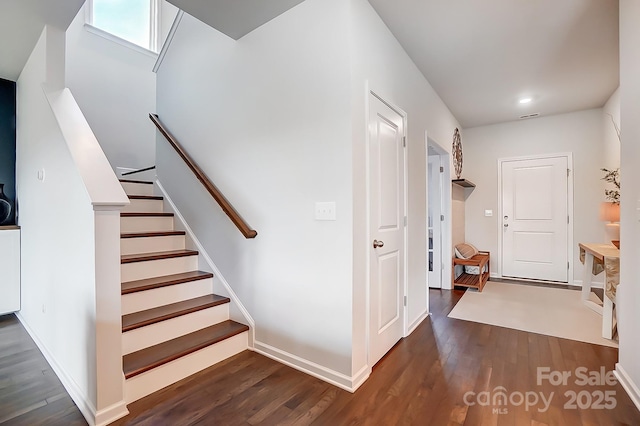 entrance foyer featuring dark wood-style floors, stairs, and baseboards