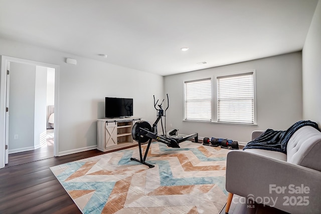 workout room featuring baseboards and wood finished floors