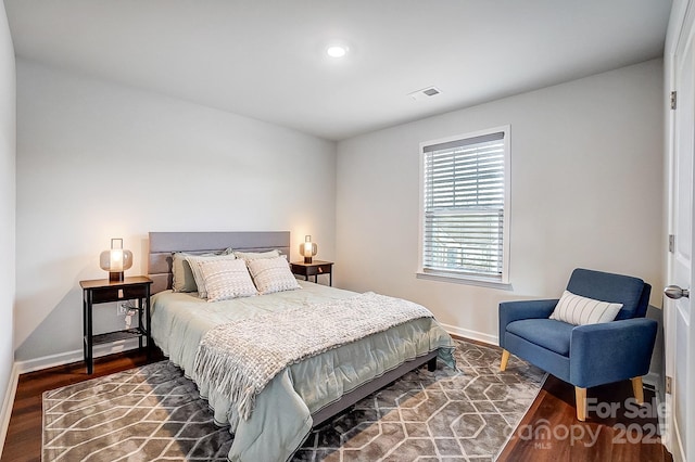 bedroom with baseboards, visible vents, and dark wood-type flooring