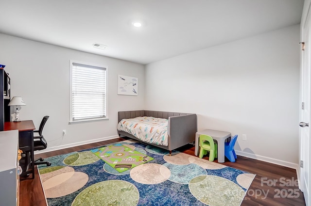 bedroom with dark wood-style floors, visible vents, and baseboards