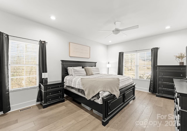 bedroom with multiple windows, ceiling fan, and light wood-type flooring