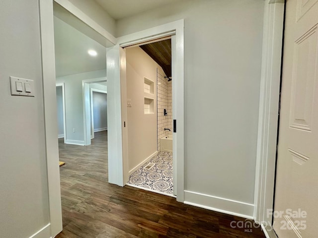 hall featuring baseboards and dark wood-style flooring