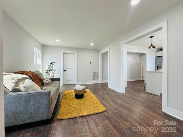 living room featuring dark wood-style flooring, recessed lighting, visible vents, and baseboards