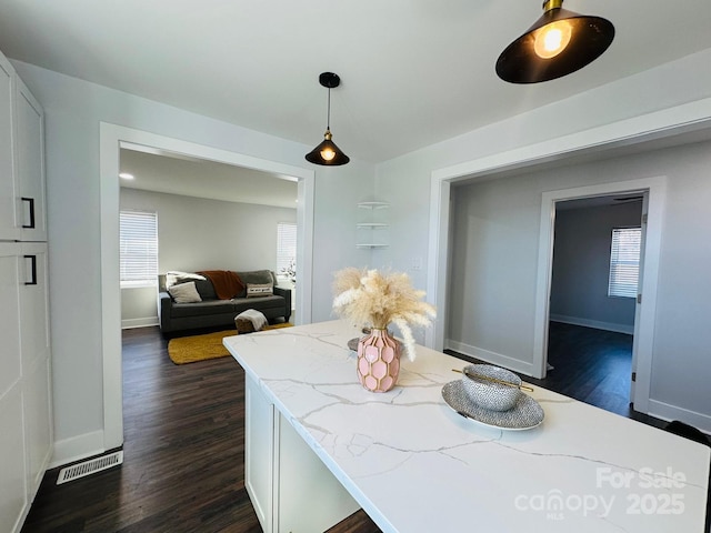 dining room with dark wood-type flooring, visible vents, and baseboards