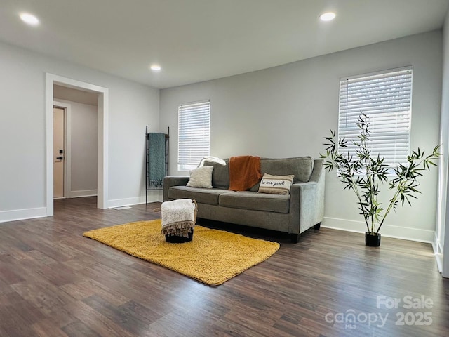 living room featuring recessed lighting, dark wood finished floors, and baseboards