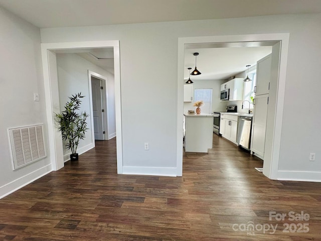 kitchen with stainless steel appliances, visible vents, white cabinets, hanging light fixtures, and light countertops