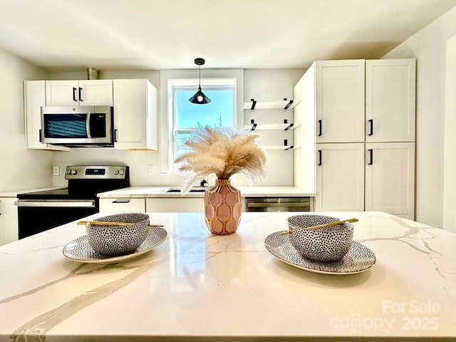 kitchen featuring white cabinets, light stone counters, decorative light fixtures, stainless steel appliances, and open shelves