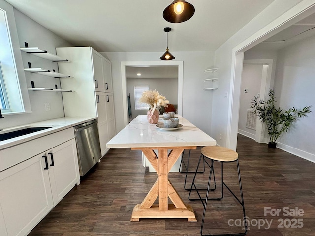 kitchen with open shelves, white cabinets, light countertops, pendant lighting, and stainless steel dishwasher