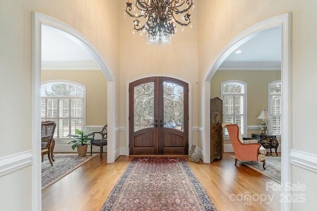 foyer with french doors, wood-type flooring, and a wealth of natural light