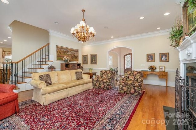 living room featuring ornamental molding, a notable chandelier, and light hardwood / wood-style flooring