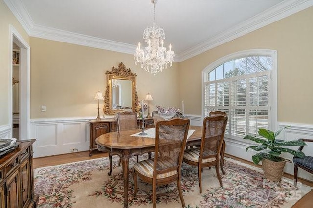 dining area featuring ornamental molding, a chandelier, and light wood-type flooring