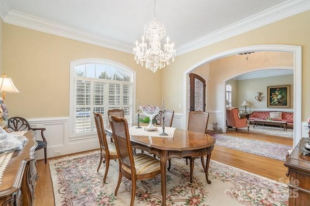 dining area featuring ornamental molding, a notable chandelier, and light hardwood / wood-style floors