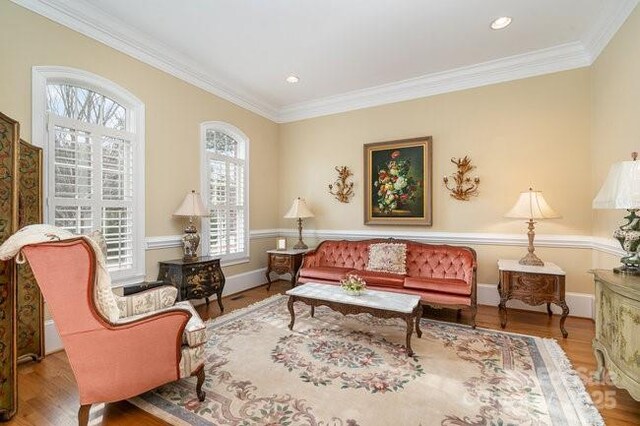 living area with ornamental molding and hardwood / wood-style floors