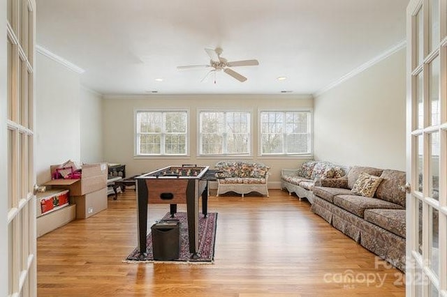 rec room with french doors, ceiling fan, crown molding, and light wood-type flooring