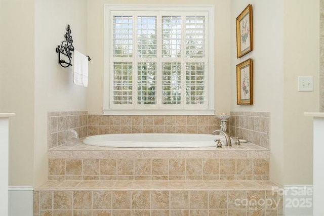 bathroom featuring a healthy amount of sunlight and tiled tub