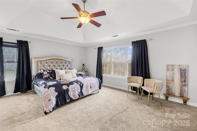 carpeted bedroom featuring a raised ceiling, crown molding, and ceiling fan