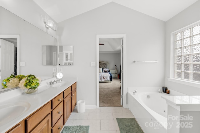 bathroom with lofted ceiling, vanity, tile patterned floors, and a healthy amount of sunlight