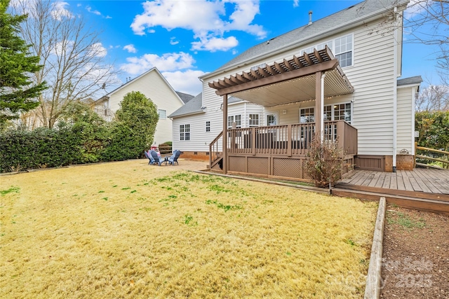 back of property with a wooden deck, a pergola, and a yard