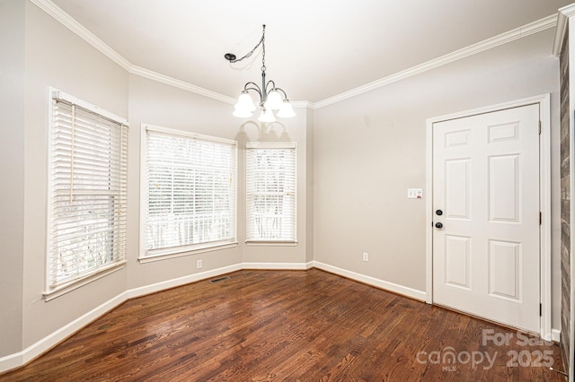 unfurnished dining area with dark wood-type flooring, crown molding, and an inviting chandelier