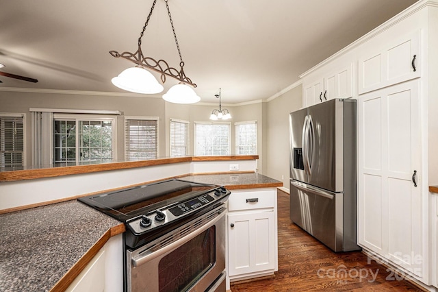 kitchen featuring crown molding, dark wood-type flooring, white cabinetry, stainless steel appliances, and decorative light fixtures