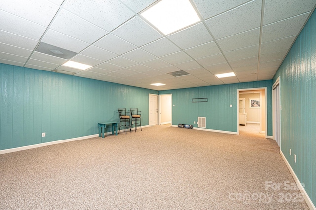 basement featuring carpet floors and a paneled ceiling