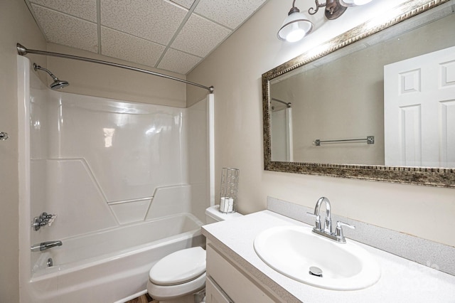 full bathroom with shower / tub combination, a paneled ceiling, vanity, and toilet