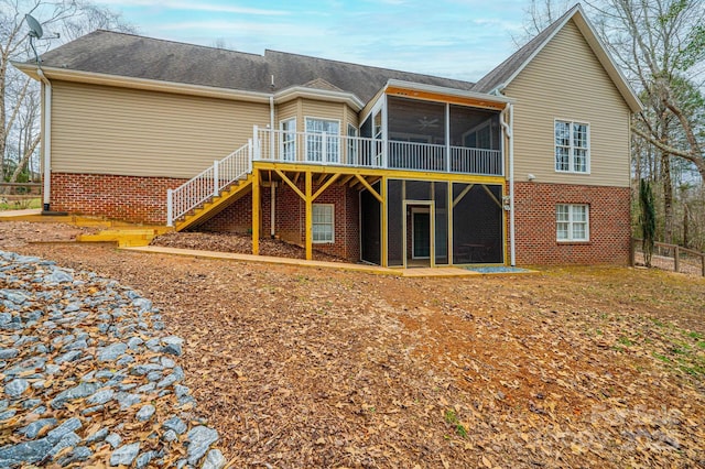 back of property with a sunroom and a deck