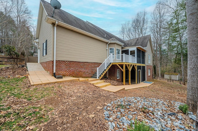 back of house featuring a wooden deck and a sunroom