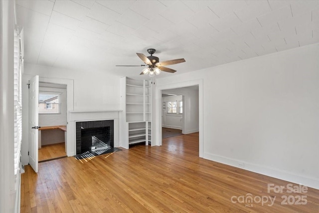 unfurnished living room with hardwood / wood-style flooring and ceiling fan