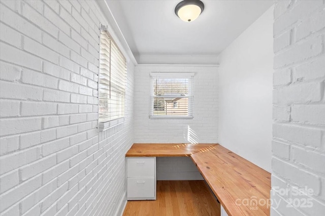 view of sauna featuring hardwood / wood-style flooring and brick wall