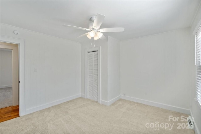 spare room featuring light carpet and ceiling fan