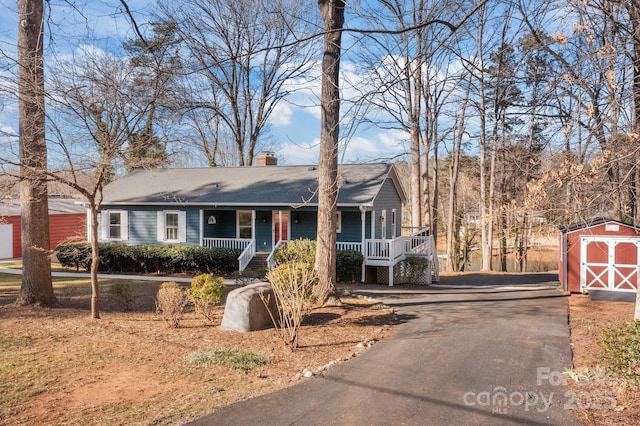 single story home featuring a porch and a shed