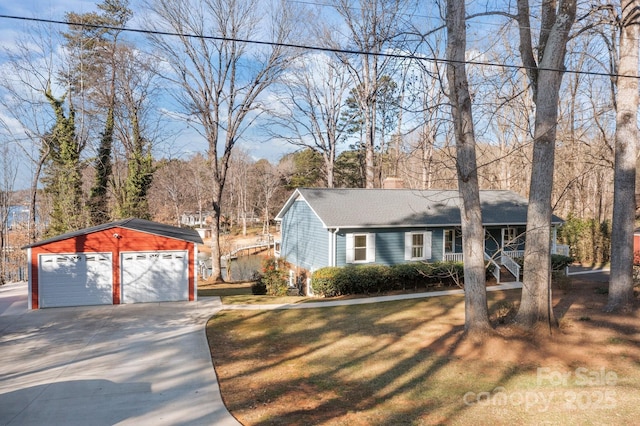 view of front of home featuring an outbuilding, a garage, and a front lawn