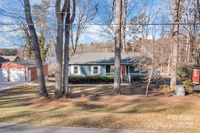 view of front of home featuring a porch, a garage, an outdoor structure, and a front lawn